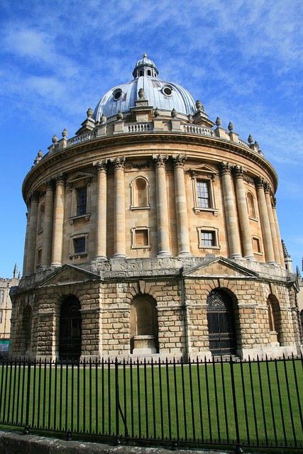 Oxford Library: a round, beige brick building with an old copper dome on top. It appears to be about three levels high with an iron fence around it.