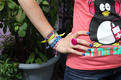 person with hand on hip, wearing woven bracelets