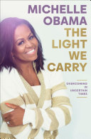 Michelle Obama is featured to the left of the cover wearing a cream and beige striped sweater. The title in gold is featured to the right of Michelle.