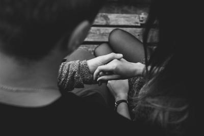 a couples holds hands in a black and white photograph