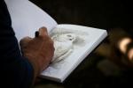 Photo of a hand drawing an owl.